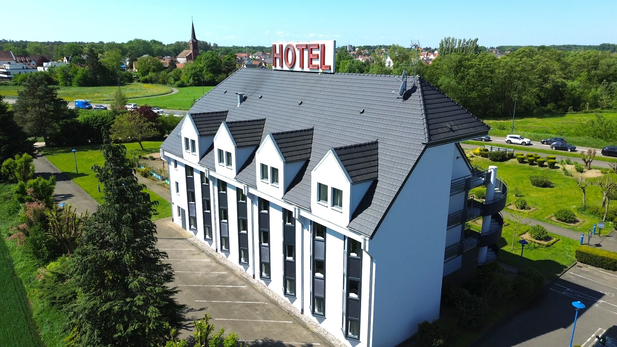 Couverture sombre et façades claires de l’hôtel photographiées depuis un drone
