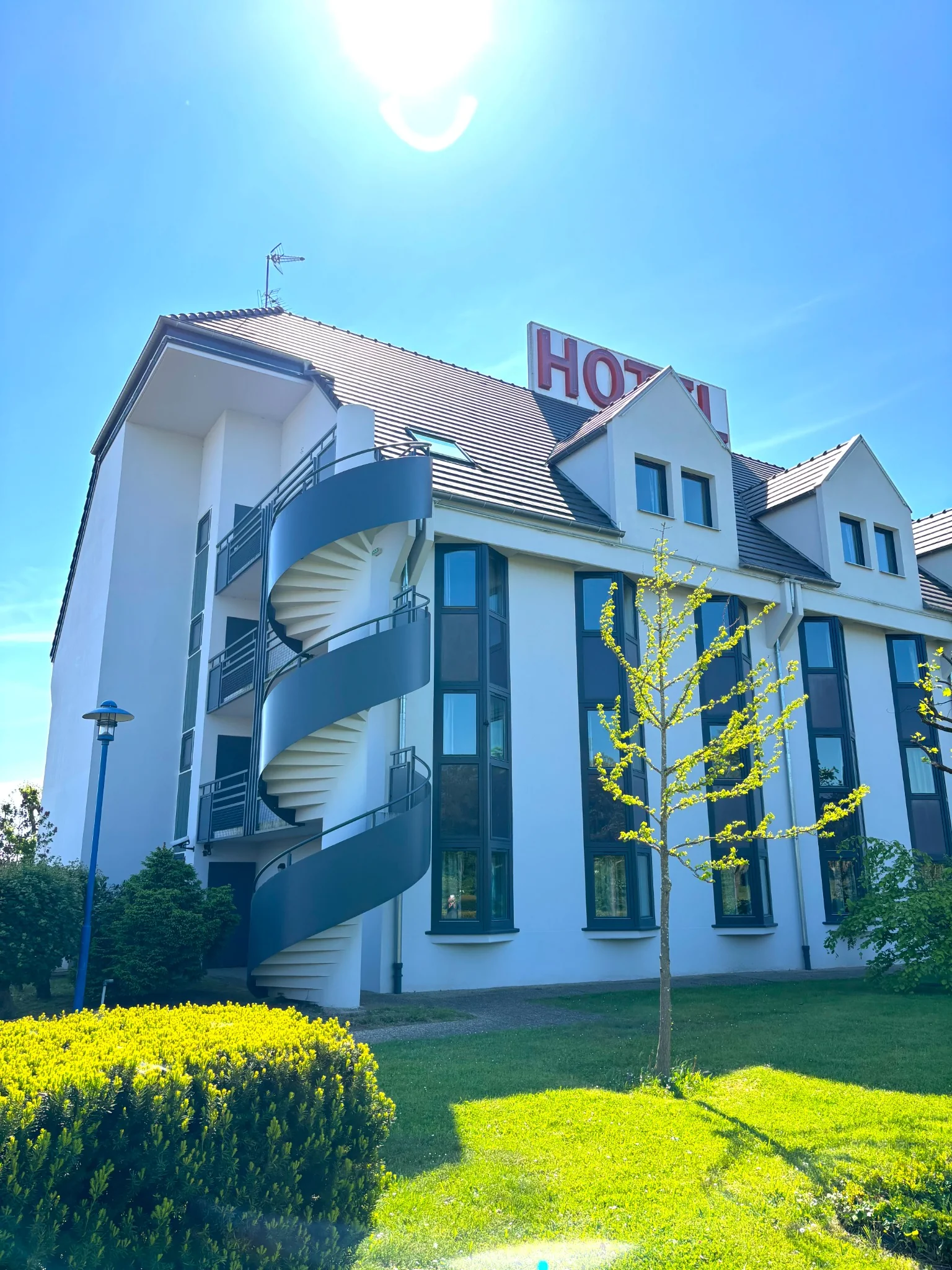 Après rénovation : façade claire de l’hôtel et escalier extérieur